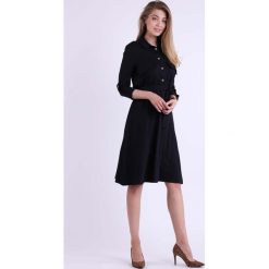 Czarna Rozkloszowana Szmizjerka z Długim Podpinanym Rękawem. Czarne sukienki damskie Molly.pl, na co dzień, s, bez wzorów, eleganckie, z klasycznym kołnierzykiem, z długim rękawem, długie, rozkloszowane. Za 196,90 zł.