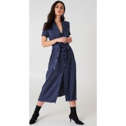 NA-KD Boho Satynowa sukienka w żakardowe kwiaty z wiązaniem - Blue. Niebieskie sukienki damskie marki NA-KD Boho, w paski, z poliesteru, boho, bez kołnierzyka, bez rękawów, maxi. W wyprzedaży za 141,97 zł.