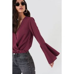 NA-KD Bluzka kopertowa - Purple. Fioletowe bluzki damskie marki NA-KD, bez wzorów, z poliesteru, bez kołnierzyka, z długim rękawem. W wyprzedaży za 30,28 zł.