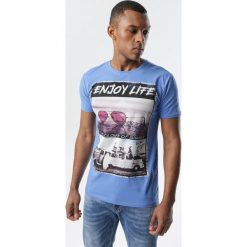 Niebieska Koszulka Kyley. Niebieskie koszulki męskie Born2be, xl, z nadrukiem, z jeansu, klasyczne, z okrągłym kołnierzem, z krótkim rękawem, krótkie. Za 39,99 zł.