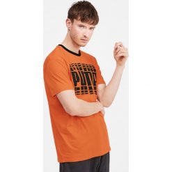 Puma Rebel Bold Koszulka Pomarańczowy. Pomarańczowe podkoszulki męskie Puma, xl, z nadrukiem, z elastanu, bez kołnierzyka, krótkie. Za 111,95 zł.