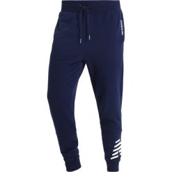 Spodnie dresowe męskie: New Balance ESSENTIALS GRAPHIC Spodnie treningowe pigment