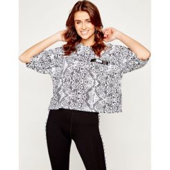 Bluzka DKNY Sport DP9T7087. Białe koszule damskie DKNY Sport, s, bez wzorów, z elastanu, sportowe, bez kołnierzyka, bez rękawów. W wyprzedaży za 139,00 zł.