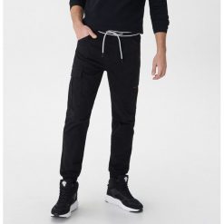 Joggery z kieszeniami cargo - Czarny. Czarne spodnie męskie marki House, s, bez wzorów. Za 119,99 zł.