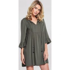 Ciemnozielona Sukienka Warbling. Zielone sukienki damskie other, na imprezę, s, z aplikacjami, bez kołnierzyka, bez rękawów, mini, rozkloszowane. Za 79,99 zł.