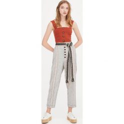 Spodnie marchewy z guzikami z przodu. Spodnie damskie Pull&Bear. Za 99,90 zł.
