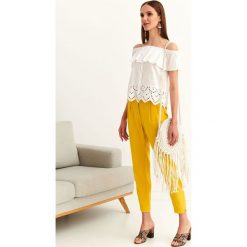 Bluzka bez rękawów o luźnym kroju. Białe bluzki damskie Top Secret, bez wzorów, z tkaniny, eleganckie, bez kołnierzyka, bez rękawów. W wyprzedaży za 49,99 zł.