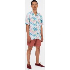Koszula w tropikalne kwiaty. Niebieskie koszule męskie Pull&Bear, m, w kwiaty, bez kołnierzyka, bez rękawów. Za 62,90 zł.