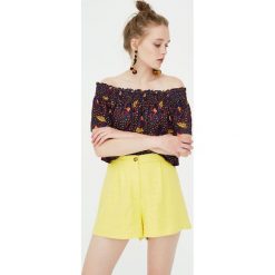 Marszczony top z afrykańskim nadrukiem. Czarne topy damskie marki Pull&Bear, z nadrukiem. Za 48,90 zł.