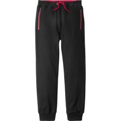 Spodnie dresowe z kieszeniami z zamkiem bonprix czarny. Czarne dresy chłopięce marki bonprix, z nadrukiem, z dresówki. Za 54,99 zł.