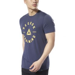 Reebok Koszulka Niebieski. Niebieskie podkoszulki męskie Reebok, m, z nadrukiem, z poliesteru, bez kołnierzyka, z krótkim rękawem, krótkie. Za 107,95 zł.