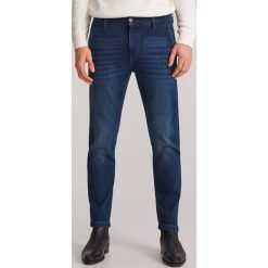 Spodnie jeansowe slim -. Spodnie męskie Reserved, bez wzorów, z jeansu. Za 99,99 zł.