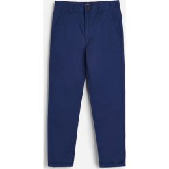 Bawełniane spodnie chino -. Spodnie męskie Reserved, bez wzorów, z bawełny. Za 59,99 zł.