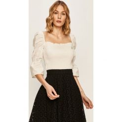 Guess Jeans - Bluzka. Czarne bluzki damskie Guess Jeans, na co dzień, s, z aplikacjami, z elastanu, z okrągłym kołnierzem, bez rękawów. W wyprzedaży za 229,90 zł.
