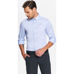 Koszula męska elegancka z jedwabistym wykończeniem tkaniny o dopasowanym kroju. Niebieskie koszule męskie Top Secret, na zimę, m, bez wzorów, z tkaniny, eleganckie, z klasycznym kołnierzykiem, bez rękawów. W wyprzedaży za 39,99 zł.
