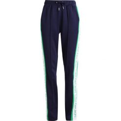 Calvin Klein Jeans SIDE STRIPE TRACK PANTS Spodnie treningowe peacoat. Niebieskie spodnie sportowe damskie marki Calvin Klein Jeans, xl, z bawełny. W wyprzedaży za 407,20 zł.