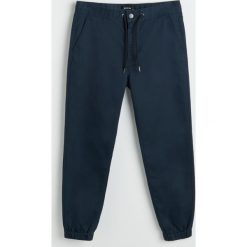 Bawełniane spodnie jogger - Granatowy. Niebieskie spodnie męskie Reserved, m, bez wzorów, z bawełny. Za 129,99 zł.