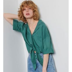 Koszula oversize z wiązaniem - Turkusowy. Niebieskie koszule damskie Reserved, bez wzorów, bez kołnierzyka, bez rękawów. Za 79,99 zł.