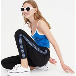 Czarne spodnie jogging z lampasami. Czarne spodnie damskie Pull&Bear. Za 79,90 zł.