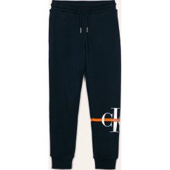 Calvin Klein Jeans - Spodnie dziecięce 116-176 cm. Niebieskie dresy chłopięce Calvin Klein Jeans, z nadrukiem, z elastanu. W wyprzedaży za 219,90 zł.