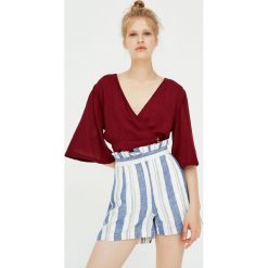 Top z rozszerzanymi rękawami i guzikami. Szare topy damskie Pull&Bear, bez wzorów, bez kołnierzyka, z krótkim rękawem. Za 59,90 zł.
