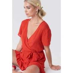 Linn Ahlborg x NA-KD Kopertowy kombinezon z krótkim rękawem - Red. Czerwone kombinezony damskie Linn Ahlborg x NA-KD, w paski, z falbankami, z krótkim rękawem, krótkie. W wyprzedaży za 60,97 zł.