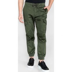 Armani Exchange Spodnie Zielony. Zielone spodnie męskie Armani Exchange, bez wzorów, z elastanu. Za 688,95 zł.