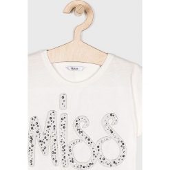 Guess Jeans - Top dziecięcy 118-175 cm. Białe bluzki dziewczęce Guess Jeans, z nadrukiem, z bawełny, z okrągłym kołnierzem, z krótkim rękawem, krótkie, bez kaptura. W wyprzedaży za 99,90 zł.