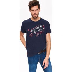 T-SHIRT Z NADRUKIEM. Niebieskie t-shirty męskie marki Top Secret, na lato, m, z nadrukiem, z bawełny, bez kołnierzyka, krótkie. W wyprzedaży za 19,99 zł.