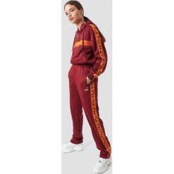 FILA Spodnie Thora Track - Red. Czerwone spodnie z wysokim stanem marki Fila, w paski, z podwyższonym stanem. Za 283,95 zł.