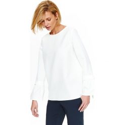 Bluzka damska elegancka z wiązaniem przy rękawach. Białe bluzki damskie Top Secret, bez wzorów, z dzianiny, eleganckie, bez kołnierzyka, z długim rękawem. W wyprzedaży za 49,99 zł.