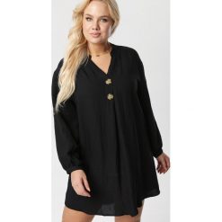 Czarna Sukienka Adreathia. Czarne sukienki damskie Born2be, xl, bez wzorów, ze stójką, z długim rękawem, długie, mini, trapezowe. Za 89,99 zł.