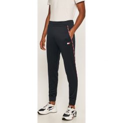 Tommy Sport - Spodnie. Niebieskie spodnie męskie Tommy Sport, na co dzień, s, z aplikacjami, z poliesteru, sportowe. Za 399,90 zł.