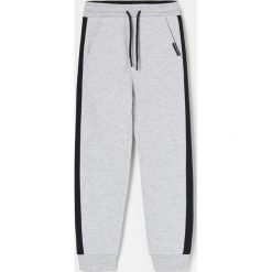Joggery z kontrastowymi lampasami -. Spodnie męskie Reserved, bez wzorów. Za 45,99 zł.