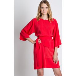 Luźna koralowa sukienka z paskiem w talii RABARBAR. Pomarańczowe sukienki damskie RABARBAR, do pracy, bez wzorów, z materiału, eleganckie, bez kołnierzyka, bez rękawów, kopertowe. W wyprzedaży za 140,00 zł.