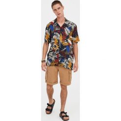 Koszula z krótkim rękawem i nadrukiem dżungli. Niebieskie koszule męskie Pull&Bear, m, z nadrukiem, bez kołnierzyka, z krótkim rękawem. Za 62,90 zł.