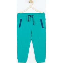 Coccodrillo - Spodnie dziecięce 62-80 cm. Zielone spodnie chłopięce COCCODRILLO, bez wzorów, z dzianiny, sportowe. W wyprzedaży za 24,90 zł.
