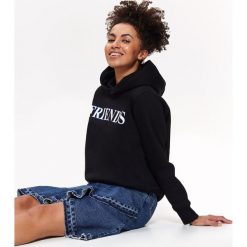 Bluza nierozpinana damska z nadrukiem. Czarne bluzy damskie Top Secret, na lato, z nadrukiem, z dzianiny, bez rękawów, z kapturem. W wyprzedaży za 49,99 zł.