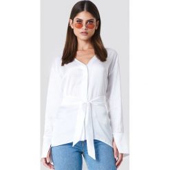 Sahara Ray x NA-KD Satynowa koszula oversize z wiązaniem - White. Białe koszule damskie Sahara Ray x NA-KD, bez wzorów, z poliesteru, bez kołnierzyka, z długim rękawem. W wyprzedaży za 70,97 zł.