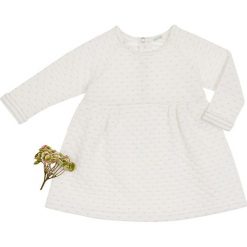 Sukienka w kolorze kremowym. Białe sukienki niemowlęce Benetton Kids, z nadrukiem, bez rękawów, midi, rozkloszowane. W wyprzedaży za 52,95 zł.