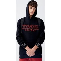 Bluza Netflix Stranger Things z kapturem. Czarne bluzy damskie Pull&Bear, m, bez wzorów, z kapturem, bez rękawów, z kapturem. Za 139,00 zł.