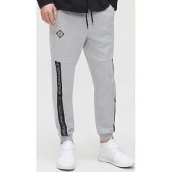 Joggery z nadrukami - Jasny szary. Szare spodnie męskie Cropp, s, z nadrukiem. Za 119,99 zł.