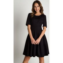 Czarna rozkloszowana sukienka BIALCON. Czarne sukienki damskie BIALCON, do pracy, na jesień, bez wzorów, eleganckie, z klasycznym kołnierzykiem, bez rękawów, rozkloszowane. W wyprzedaży za 258,00 zł.