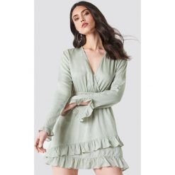 Linn Ahlborg x NA-KD Kopertowa sukienka - Green. Zielone długie sukienki marki Linn Ahlborg x NA-KD, z kopertowym dekoltem, z długim rękawem, kopertowe. Za 161,95 zł.