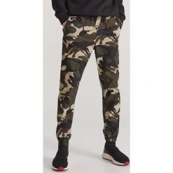 Bawełniane spodnie jogger - Zielony. Zielone spodnie męskie Reserved, m, bez wzorów, z bawełny. Za 129,99 zł.