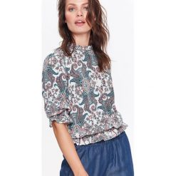 Bluzka tkaninowa w fantazyjny wzór. Białe bluzki damskie Top Secret, bez wzorów, z tkaniny, eleganckie, z falbankami, z krótkim rękawem. W wyprzedaży za 49,99 zł.