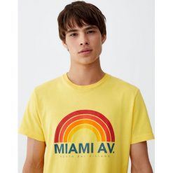 Bawełniana koszulka „Miami Av.”. Białe koszulki męskie Pull&Bear, m, bez wzorów, z bawełny, bez kołnierzyka, z krótkim rękawem, krótkie. Za 29,90 zł.
