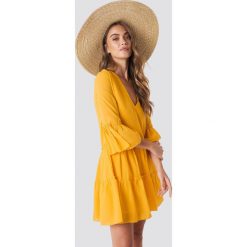 NA-KD Boho Sukienka mini z dekoltem V - Yellow. Żółte sukienki damskie NA-KD Boho, bez wzorów, z tkaniny, boho, z falbankami, bez rękawów, mini. Za 121,95 zł.