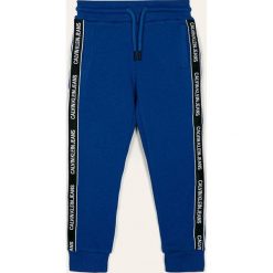 Calvin Klein Jeans - Spodnie dziecięce. Niebieskie spodnie chłopięce Calvin Klein Jeans, bez wzorów, z bawełny, casualowe. Za 259,90 zł.