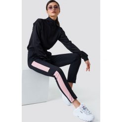 NA-KD Spodnie sportowe - Black. Czarne spodnie damskie marki NA-KD, bez wzorów, z poliesteru. W wyprzedaży za 66,97 zł.